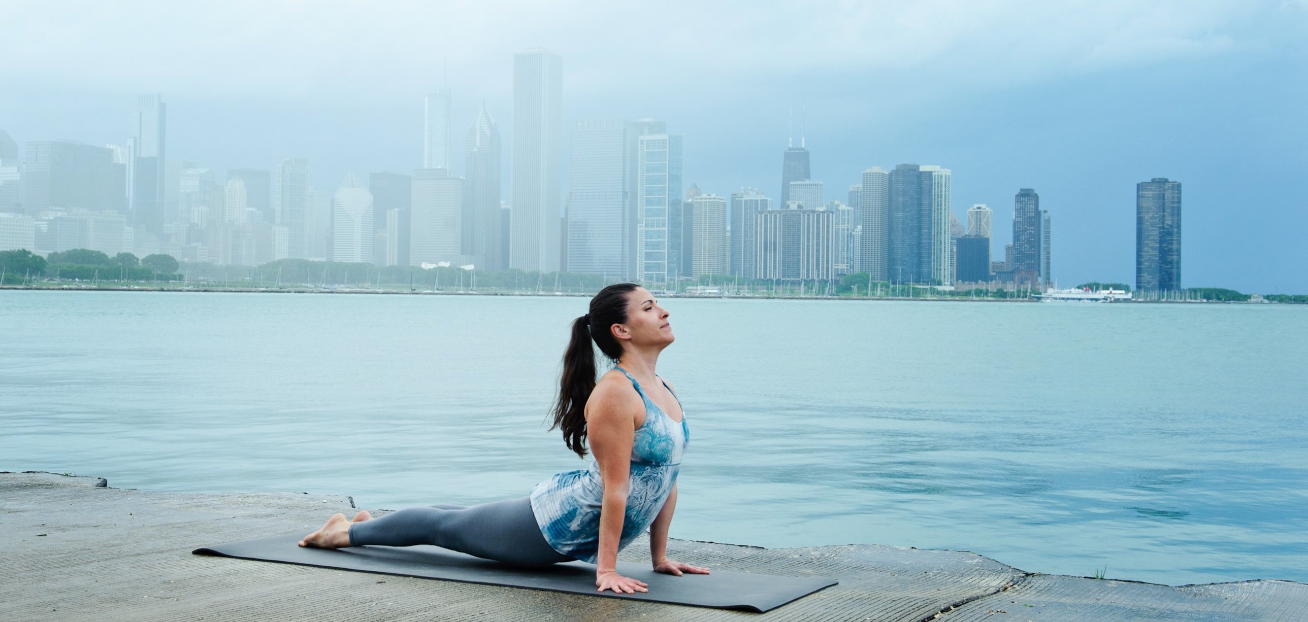 Victoria practicing yoga on the lakefront with the Chicago skyline in the background